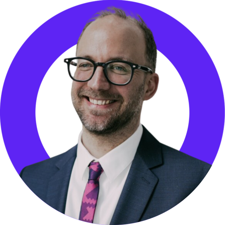 Smiling professional man in blue suit with stylish glasses, ideal for business profiles.
