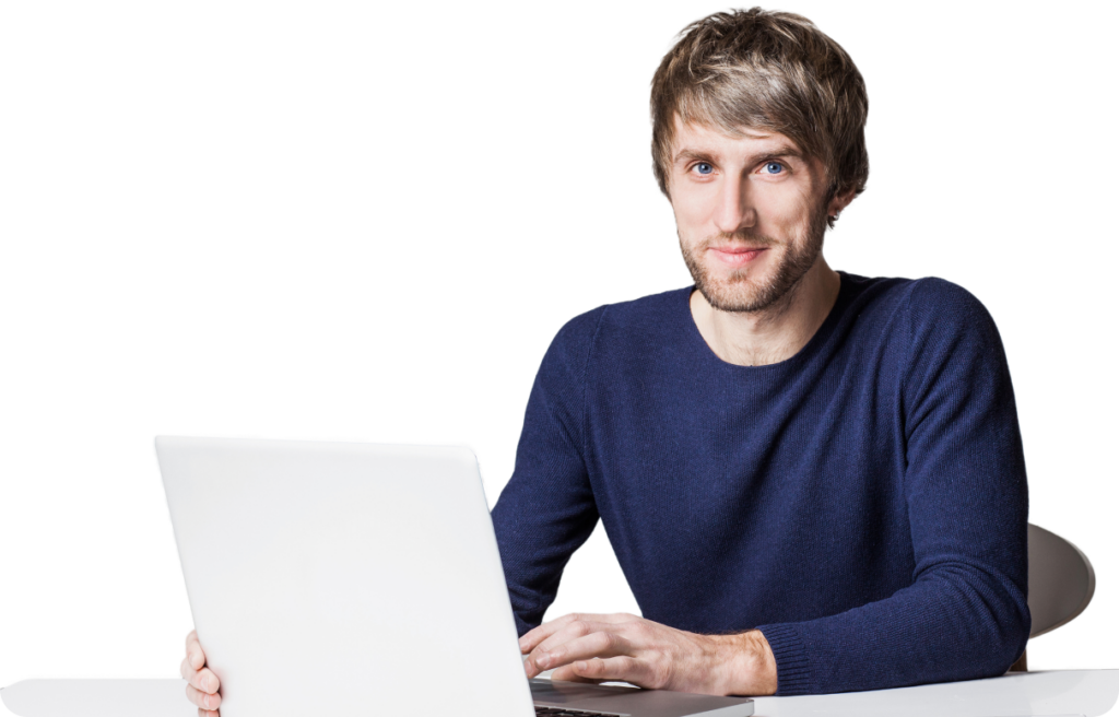 Young man in navy shirt focused on laptop in a minimalist office setting.