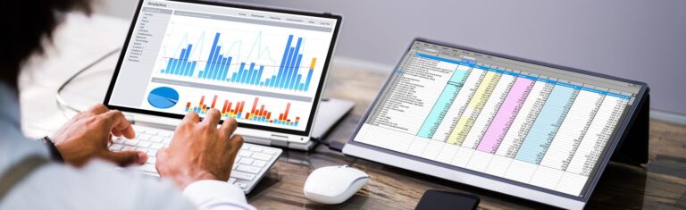 Beitragsbild zum Blogartikel Bildungsgutschein Bayern. Eine Person sitzt vor zwei Bildschirmen mit Datentabellen und Diagrammen.