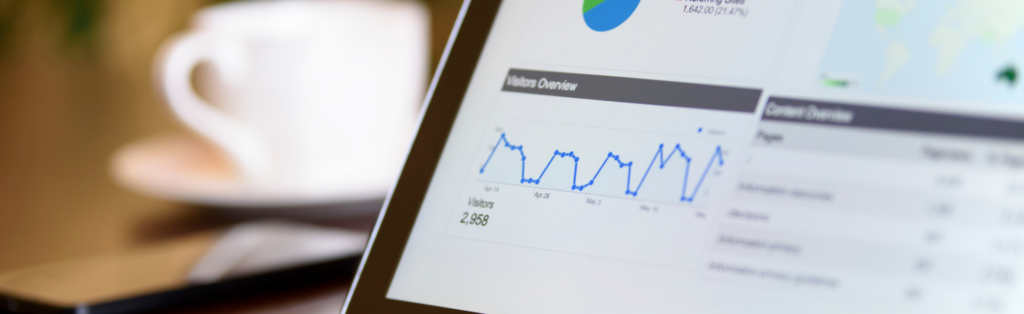 Digital web analysis tools and dashboards on a monitor in a modern office environment with a coffee cup.